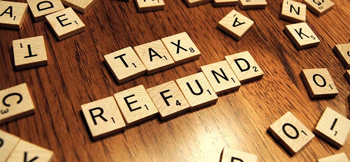 Image of scrabble board pieces spelling out tax refund for Quotacy blog 7 Great (and Smart) Ways to Spend Your Tax Refund.